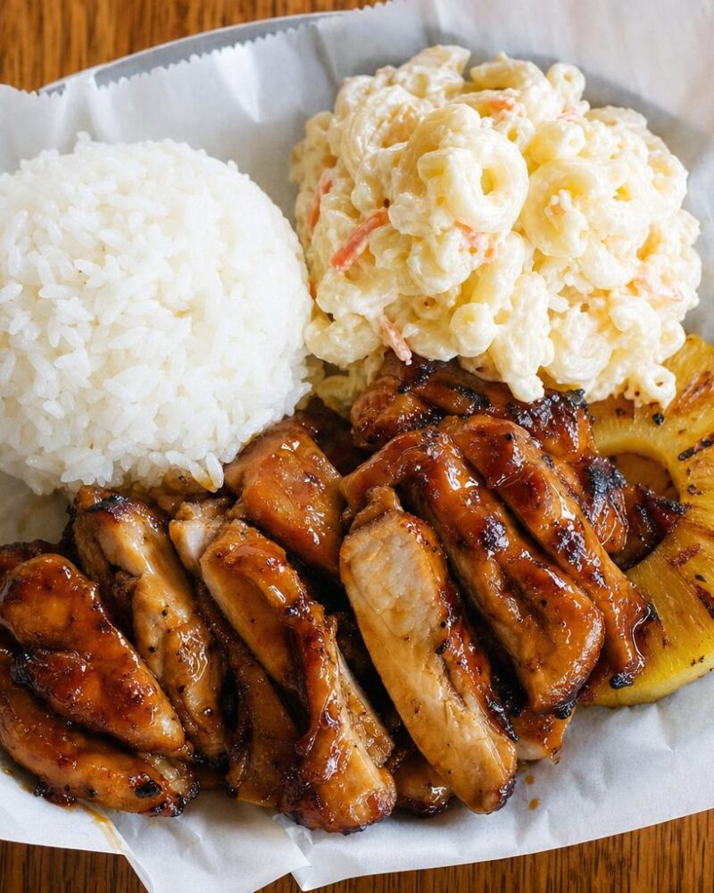 Hawaiian Plate Lunch - rice, macaroni salad and teriyaki chicken on a paper-lined plate